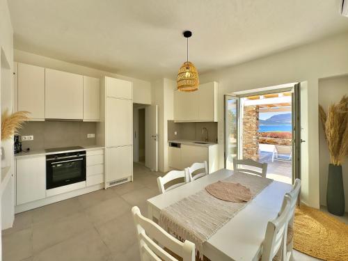 a kitchen and dining room with a table and chairs at Farous seaside sunset villa in Agios Georgios