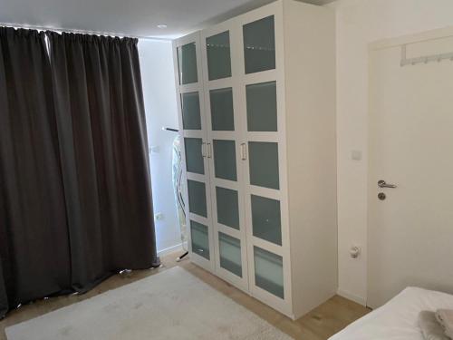 a bedroom with a closet with glass doors at Apartment Dubravko mit Meerblick 100 m Strand, Parking in Maslenica