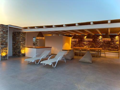 a room with chairs and a counter and a table at Farous seaside sunset villa in Agios Georgios