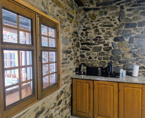 a stone kitchen with a counter and a window at Casa Dos Avós - Alojamento Local in Bragança