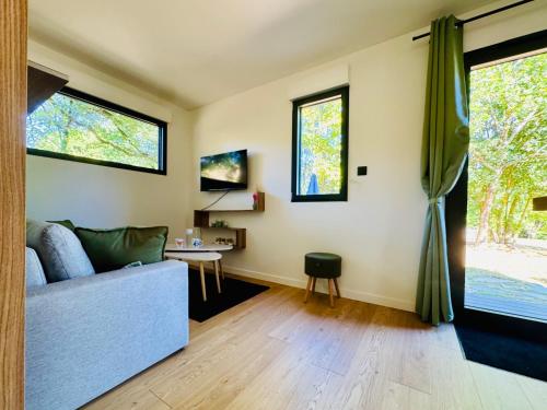 a living room with a couch and a table at Domaine du Mafay - LODGE BROCÉLIANDE in Bourg-des-Comptes