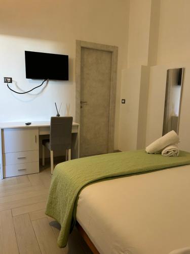 a bedroom with a bed and a desk with a television at Brezza di Mare Rooms Palinuro in Centola