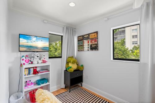 a childs room with white walls and windows at Just Beachy By Beachside Management in Siesta Key