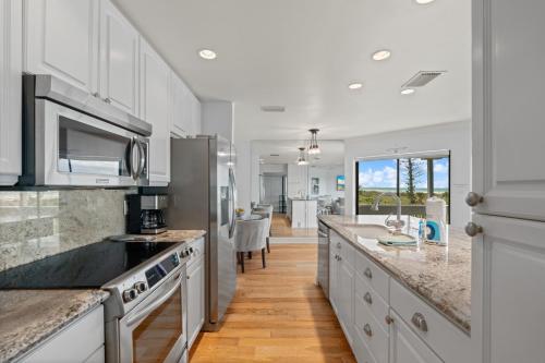 a kitchen with white cabinets and a large counter top at Just Beachy By Beachside Management in Siesta Key
