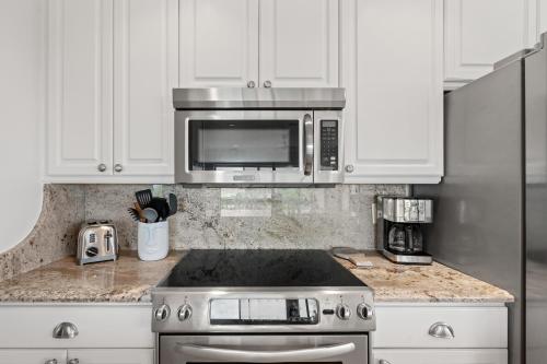 a kitchen with a stove and a microwave at Just Beachy By Beachside Management in Siesta Key