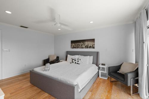a white bedroom with a bed and a chair at Just Beachy By Beachside Management in Siesta Key
