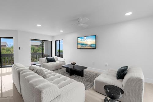 a living room with two white couches and a table at Just Beachy By Beachside Management in Siesta Key