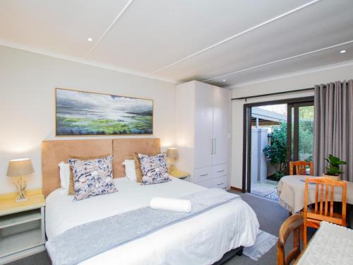 a bedroom with a large bed and a window at Eikelower Accommodation in Stellenbosch