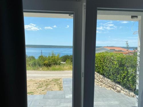 a view of the ocean from a window at Apartment Dubravko mit Meerblick 100 m Strand, Parking in Maslenica