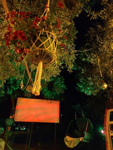a view of a tree with a bench and flowers at Asmanis Rooms in Tarti