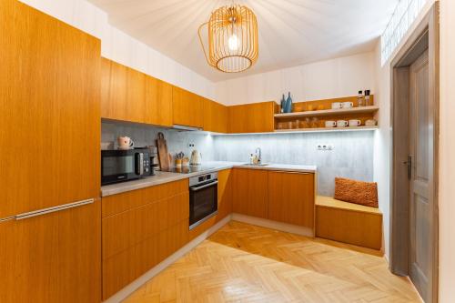 a kitchen with wooden cabinets and a microwave at Byteček v parku in Šumperk