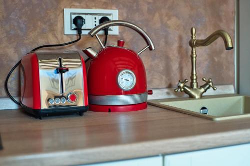 Ein roter Toaster steht auf der Arbeitsplatte neben einem Waschbecken. in der Unterkunft Free Parking Ap1 Romantic Garden Venice in Zelo