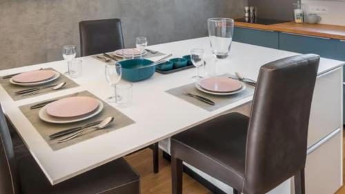 a white table with chairs and plates and silverware at Chalet Rte Brigues Courchevel in Courchevel