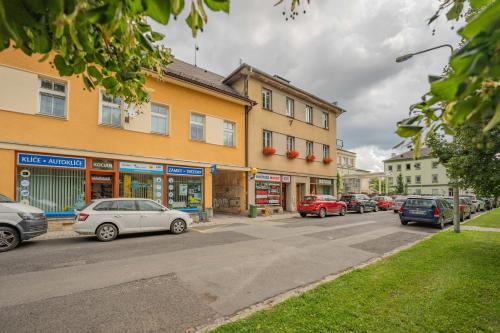 a street with cars parked in front of buildings at Byteček v parku in Šumperk