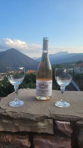 a bottle of wine and two glasses on a table at The House in the Cobbled Road in Karpenision