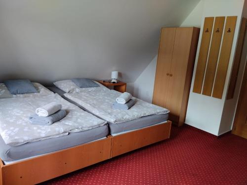 a bedroom with a bed and a small cabinet at Pension U Háčků in Harrachov