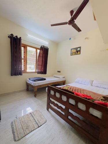 a bedroom with a bed and a ceiling fan at Thotadagadde Homestay in Mudigere