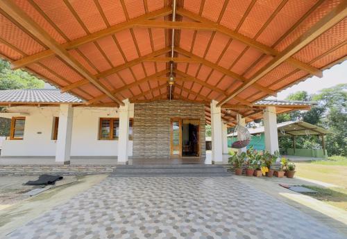 an outdoor pavilion with a wooden roof at Thotadagadde Homestay in Mudigere