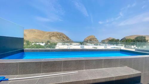 a swimming pool with a view of some mountains at Amplio departamento vista al mar con piscina privada en Asia Ideal para grupos y familias in Asia