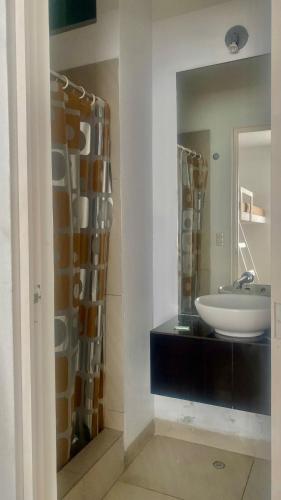 a bathroom with a sink and a mirror at Amplio departamento vista al mar con piscina privada en Asia Ideal para grupos y familias in Asia