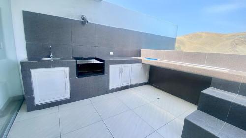 a small kitchen with a sink and a counter at Amplio departamento vista al mar con piscina privada en Asia Ideal para grupos y familias in Asia