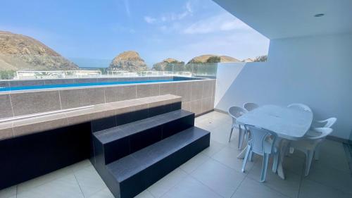 a house with a swimming pool and a table and chairs at Amplio departamento vista al mar con piscina privada en Asia Ideal para grupos y familias in Asia