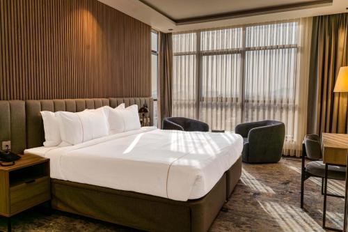 a hotel room with a bed and a large window at فندق هيل Hill Hotel in Al Madinah