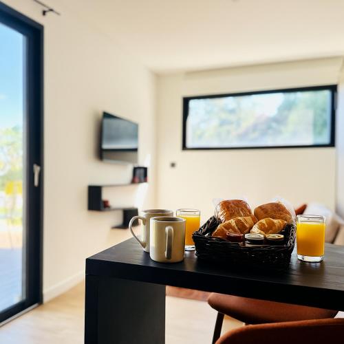 een tafel met een broodmand en twee glazen sinaasappelsap bij Domaine du Mafay - LODGE PROVENÇALE in Bourg-des-Comptes