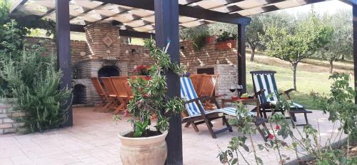 a patio with chairs and a stone fireplace at I Tre Laghi Countryhouse 14 posti letti Cottage 10 posti letti in Citta' Sant'Angelo