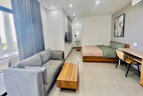a living room with a couch and a bed and a table at HPT Home II Vinhome Marina chuỗi Apartment - Homestay in Hai Phong