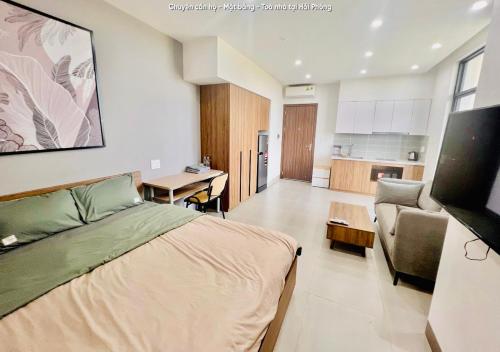 a bedroom with a bed and a couch and a kitchen at HPT Home II Vinhome Marina chuỗi Apartment - Homestay in Hai Phong