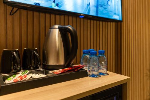 a counter with a coffee pot and bottles of water at فندق هيل Hill Hotel in Al Madinah