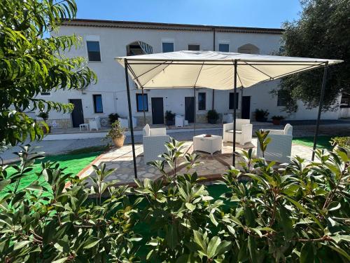 aige umbrella and chairs in front of a building at Brezza di Mare Rooms Palinuro in Centola