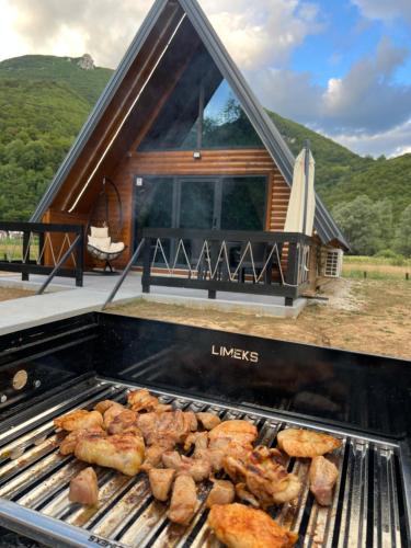 a grill with food on it in front of a house at Vila Jezero-Jajce in Jezero