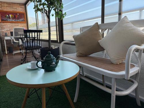 a tea pot on a table next to a chair at Departamento en Condominio Edificio Innova 306 in Copiapó