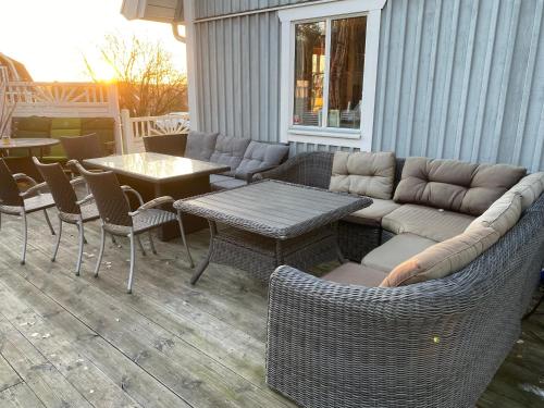 a patio with a couch and a table and chairs at DR ÅSA Apartment Penthouse w Pool by the Forest near a Golf course, Concerts and the Baltic Sea in Järna