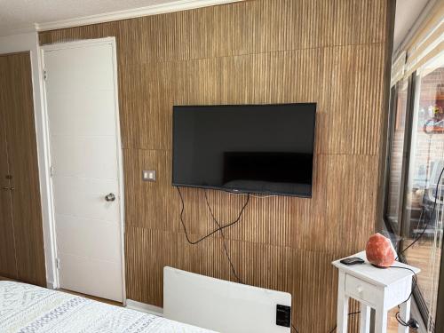 a bedroom with a tv on a wooden wall at Departamento en Condominio Edificio Innova 306 in Copiapó