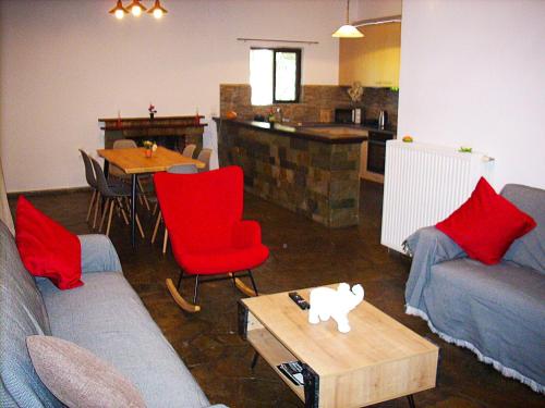 a living room with a couch and red chairs and a table at Sea view house I in Dhílesi