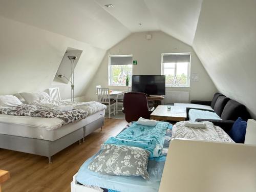 a living room with two beds and a couch at DR ÅSA Apartment Penthouse w Pool by the Forest near a Golf course, Concerts and the Baltic Sea in Järna