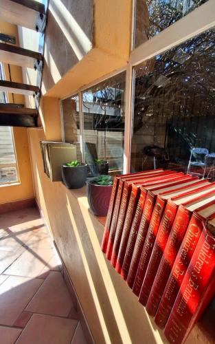 a row of red books sitting on a bench at The Loft in Bloemfontein