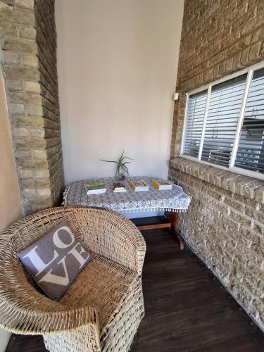 a patio with a table and chairs and a brick wall at The Loft in Bloemfontein