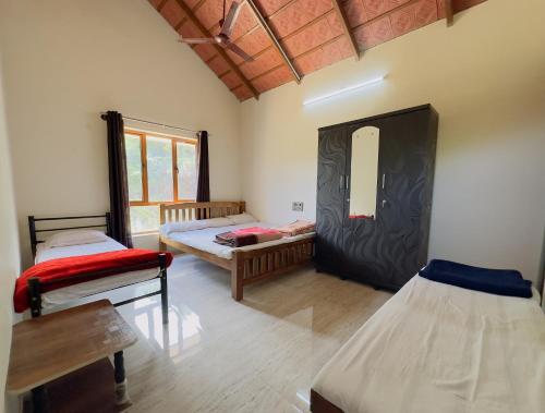 a room with two beds and a mirror at Thotadagadde Homestay in Mudigere