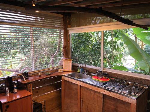 a kitchen with a sink and two large windows at "refugio entre montañas" lalomaecolodge in Dosquebradas