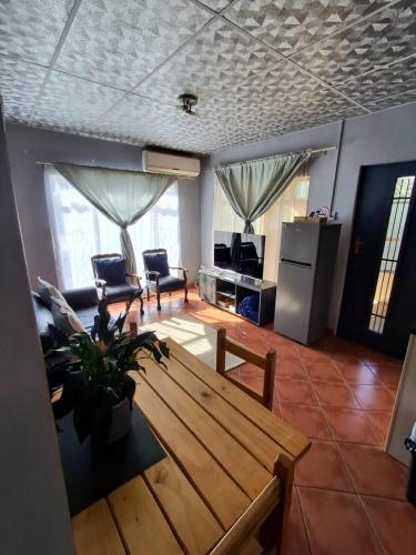 a living room with a wooden table and a kitchen at The Loft in Bloemfontein