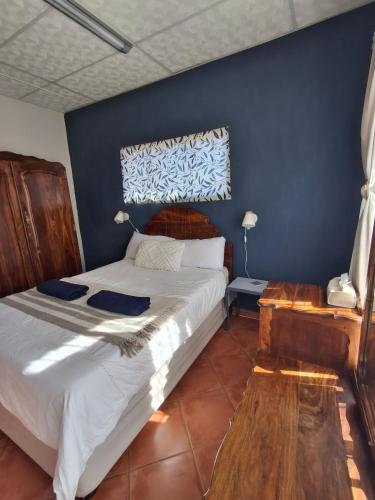 a bedroom with a bed and a blue wall at The Loft in Bloemfontein