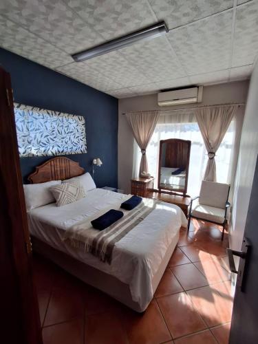 a bedroom with a large bed and a blue wall at The Loft in Bloemfontein