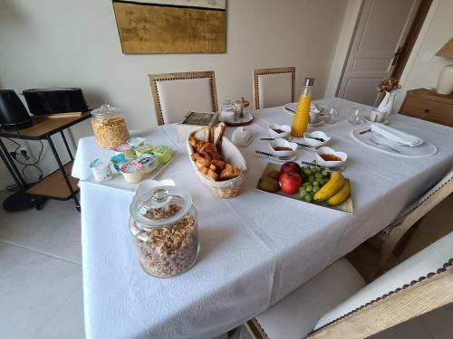 a table with a white table cloth with food on it at Le Charme des Bastides in Castelnau-de-Montmiral
