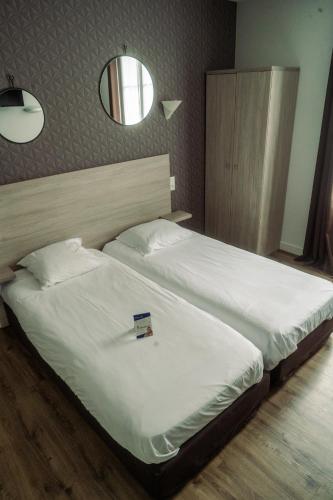 Ένα ή περισσότερα κρεβάτια σε δωμάτιο στο LOGIS -Hotel & Restaurant de la Place