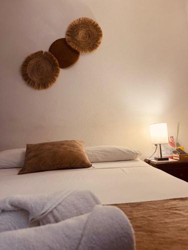 a bedroom with a bed with two hats on the wall at Aura Hotel Parque Barichara By Infinity in Barichara