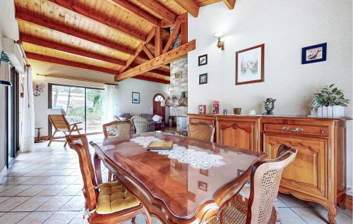 une salle à manger avec une table et des chaises en bois dans l'établissement Awesome Home In La Faute Sur Mer, à La Faute-sur-Mer